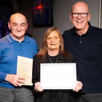 Three people smile with award. Burnbank community Hub. 