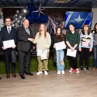 Group stand smiling on stage. Young Person Achievement Award.