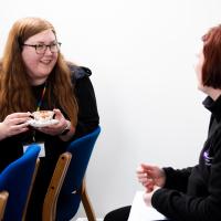 Two women laugh as they are seen talking at the event. 