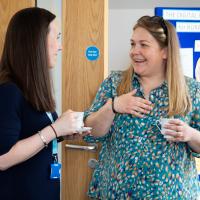 Two women laugh as they are seen talking at the event. 